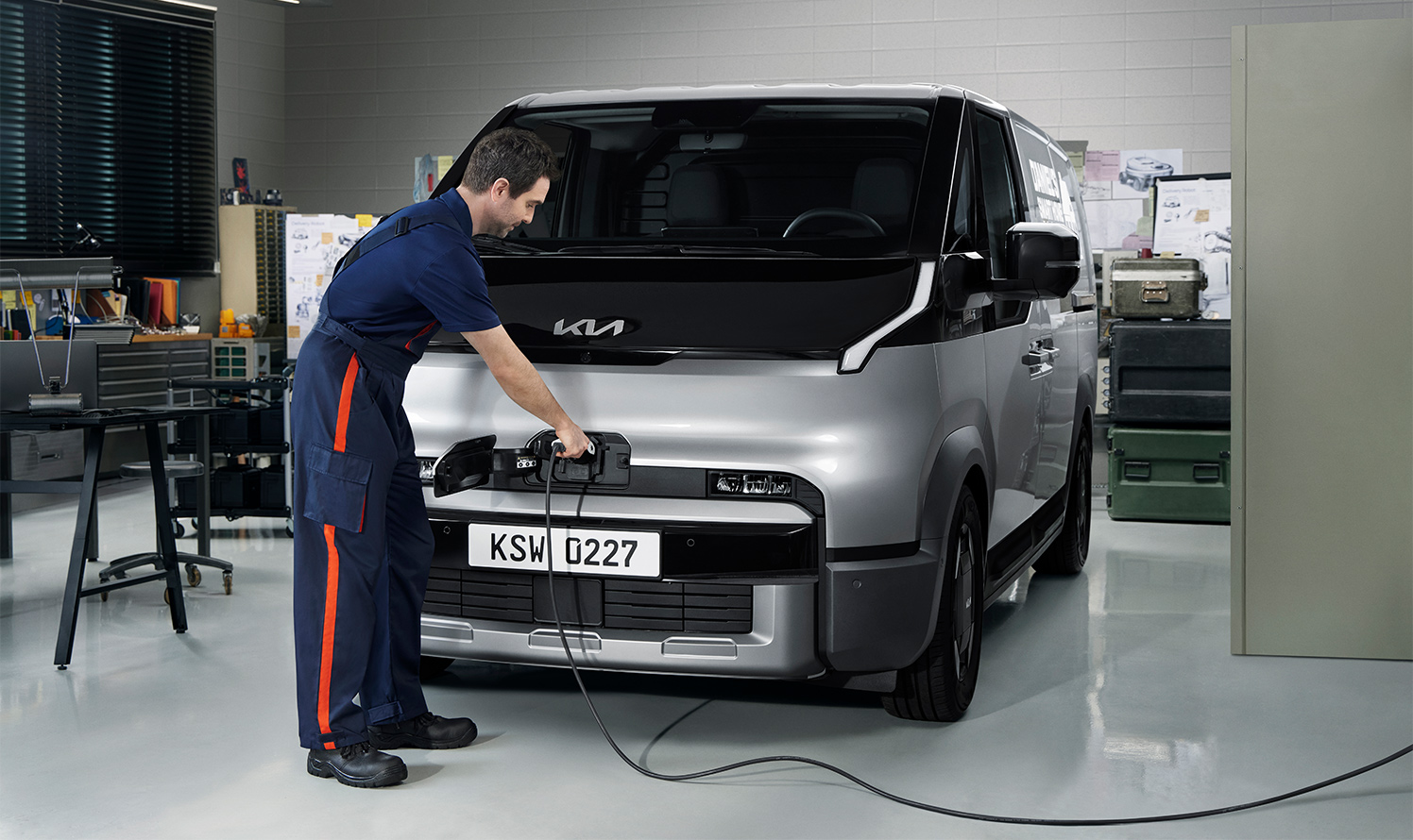 Mann schließt PV5 Cargo in einer Werkstatt zum Laden an