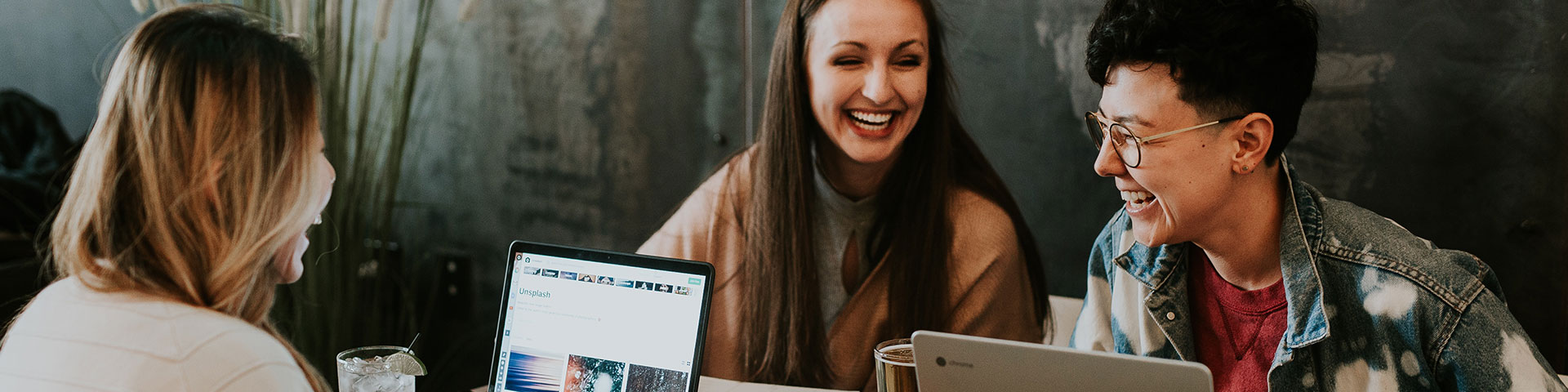 Lachende Menschen mit Laptops