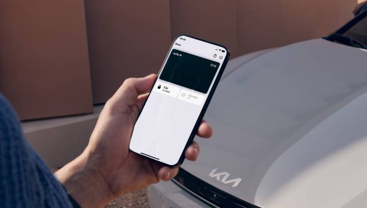 Ein Handy-Screen mit dem Kia Digital Key vor einem Kia EV6.