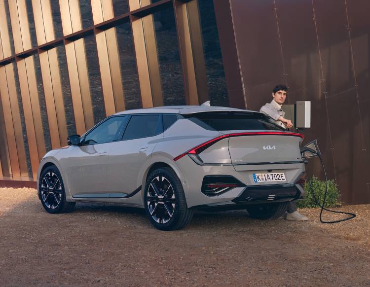 Ein Mann, der seinen Kia EV6 zuhause  lädt.