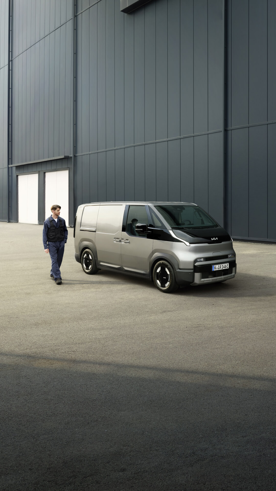 Ein Mann vor einem Kia PV5 in der Seitenansicht.