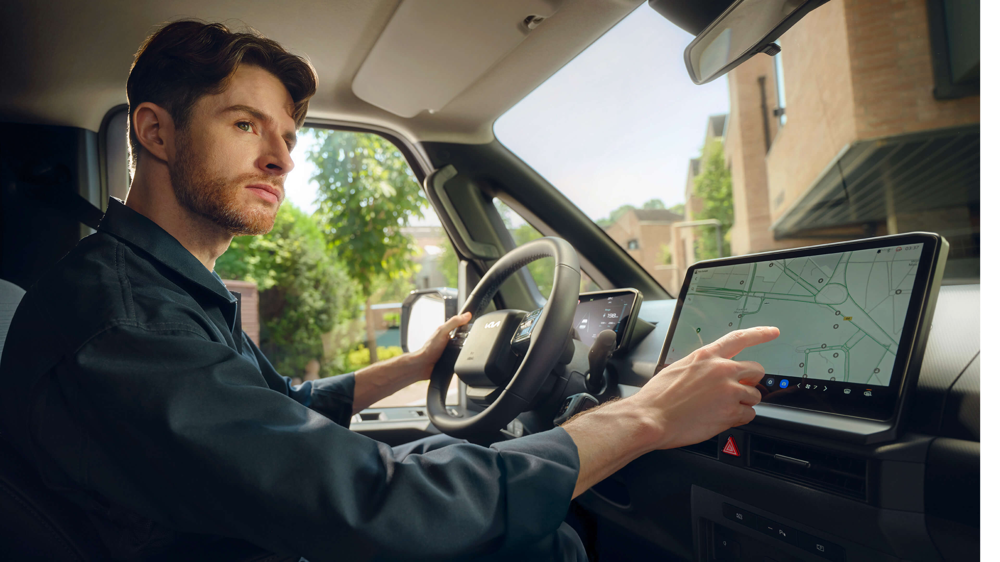 Ein Mann bedient den Touchscreen eines Kia PV5.