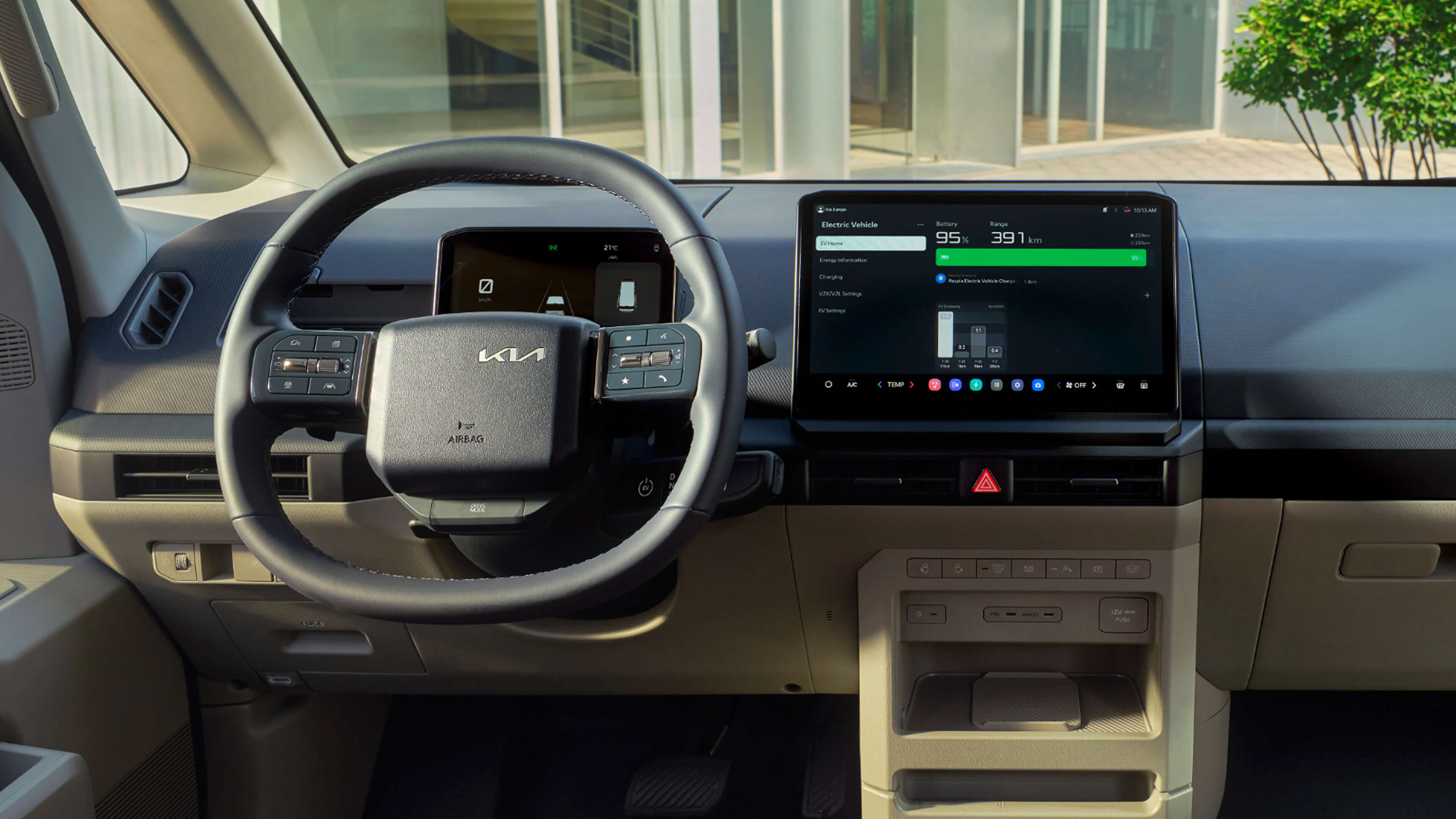 Innenansicht eines Kia PV5 mit Lenkrad und Display.