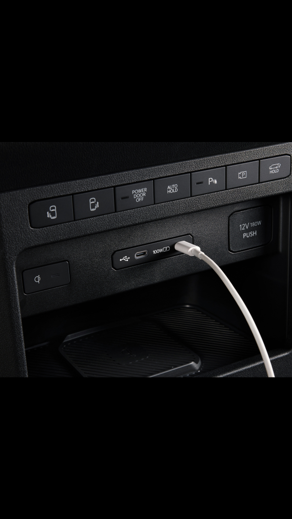 Close-up of the Kia PV5 Cargo dashboard USB port with cable connected