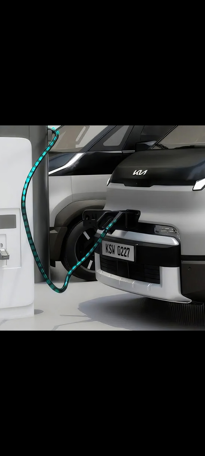 Partial front view of the Kia PV5 Cargo connected to charging station