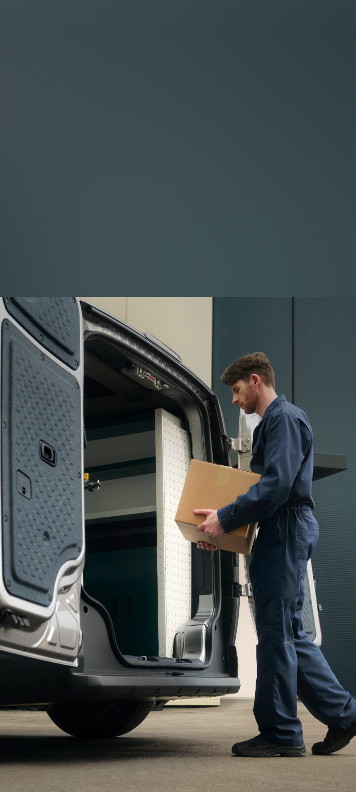 Delivery worker unloading boxes from the Kia PV5 Cargo rear