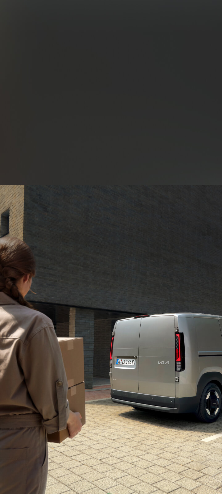 Worker unloading bread crates from the Kia PV5 Cargo side door