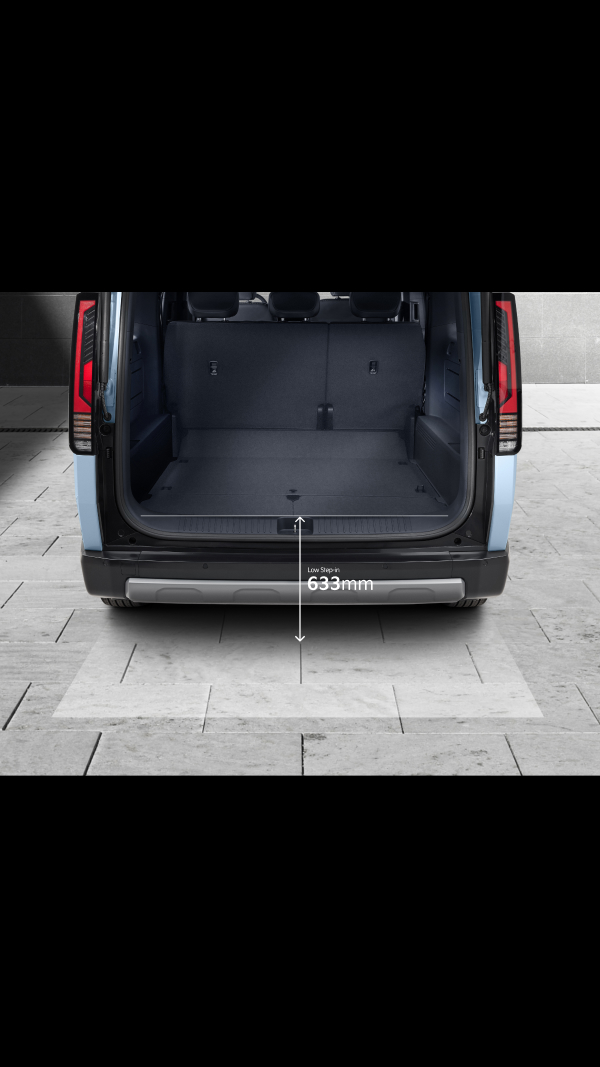 Rear view of the Kia PV5 Passenger with its tailgate open, highlighting a 1,326 mm-wide rear opening and a low 633 mm step height for easy loading of family luggage or business cargo.