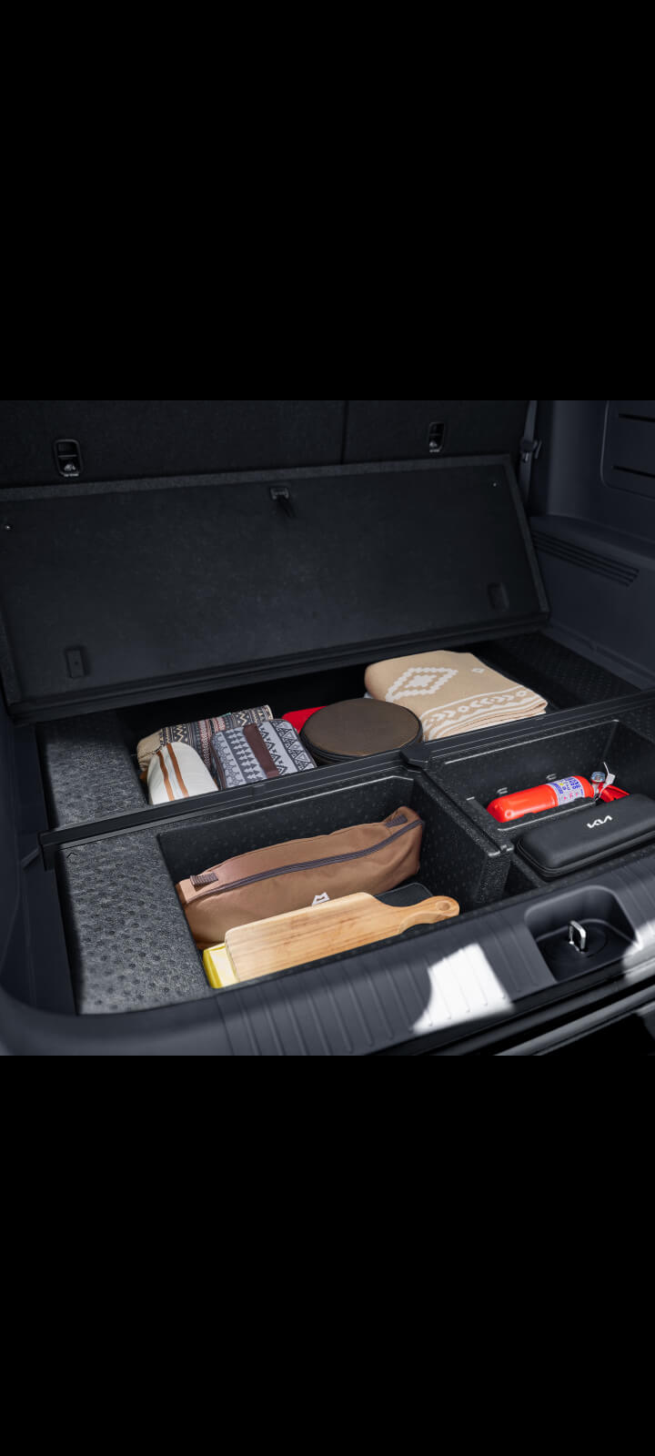 Interior close-up of the Kia PV5 Passenger seatback with integrated fold-down tray table