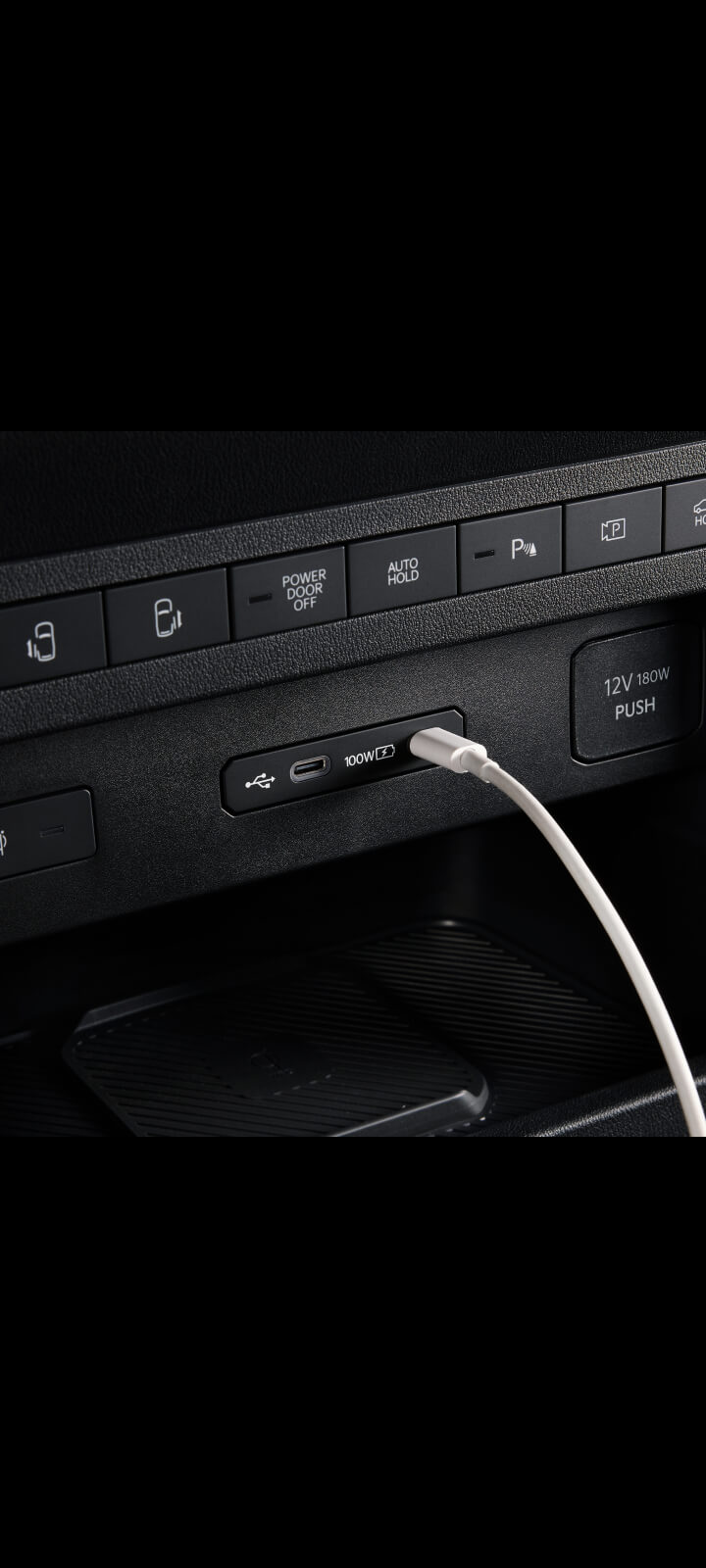 Close-up of the Kia PV5 Passenger dashboard USB port with cable connected