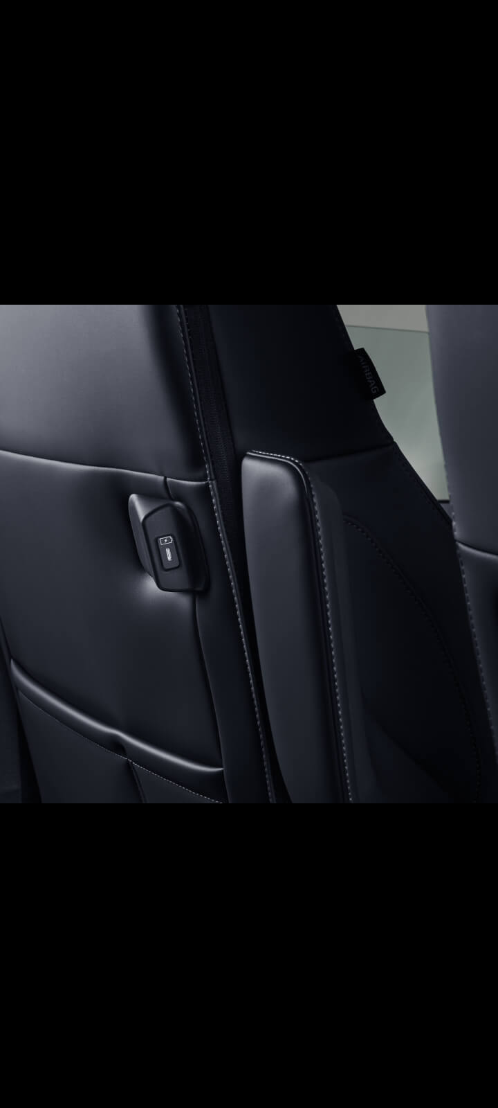 Close-up of the Kia PV5 Passenger front seatback with built-in USB-C charging port