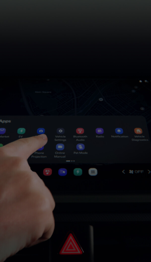 Finger pointing at an in-car display showing multiple app icons on the screen