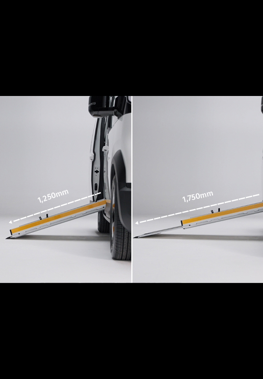 Eine Person fährt die zweistufige, im Boden integrierte Rampe am seitlichen Einstieg eines Kia PV5 WAV aus, um den Zugang für Rollstuhlfahrer zu ermöglichen.