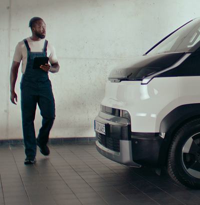 Kia technician with tablet initiating vehicle diagnostics for maintenance.