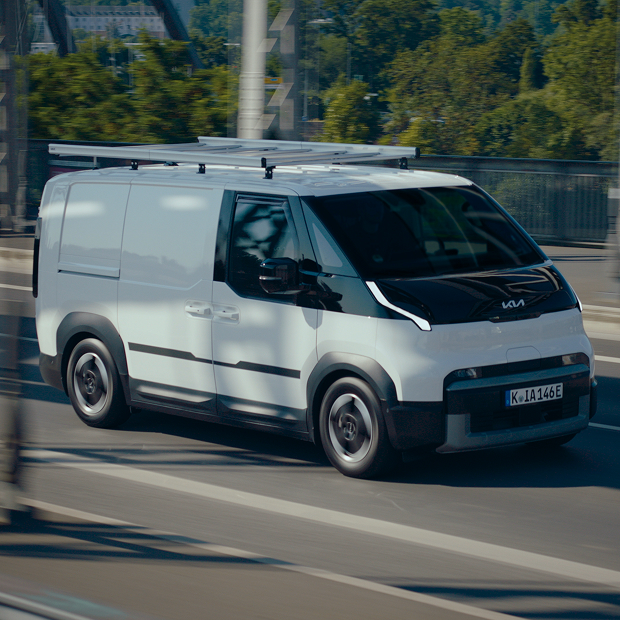 Freshly serviced Kia PV5 driving through the city.