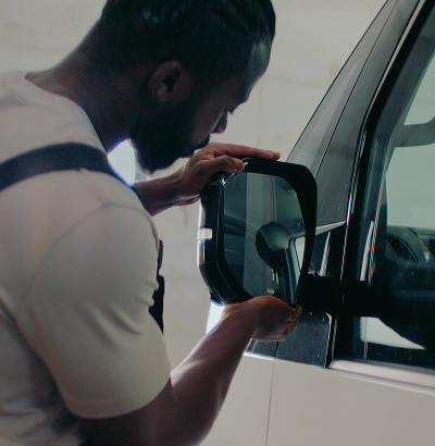  Kia technician inspecting newly replaced body part during final quality check.