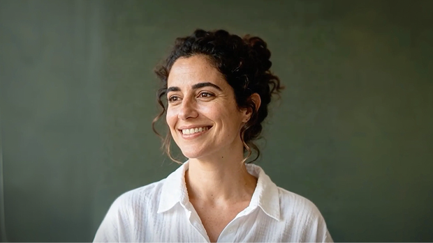 Happy woman looking at her well-maintained older Kia serviced through the Kia Service 5+ program.