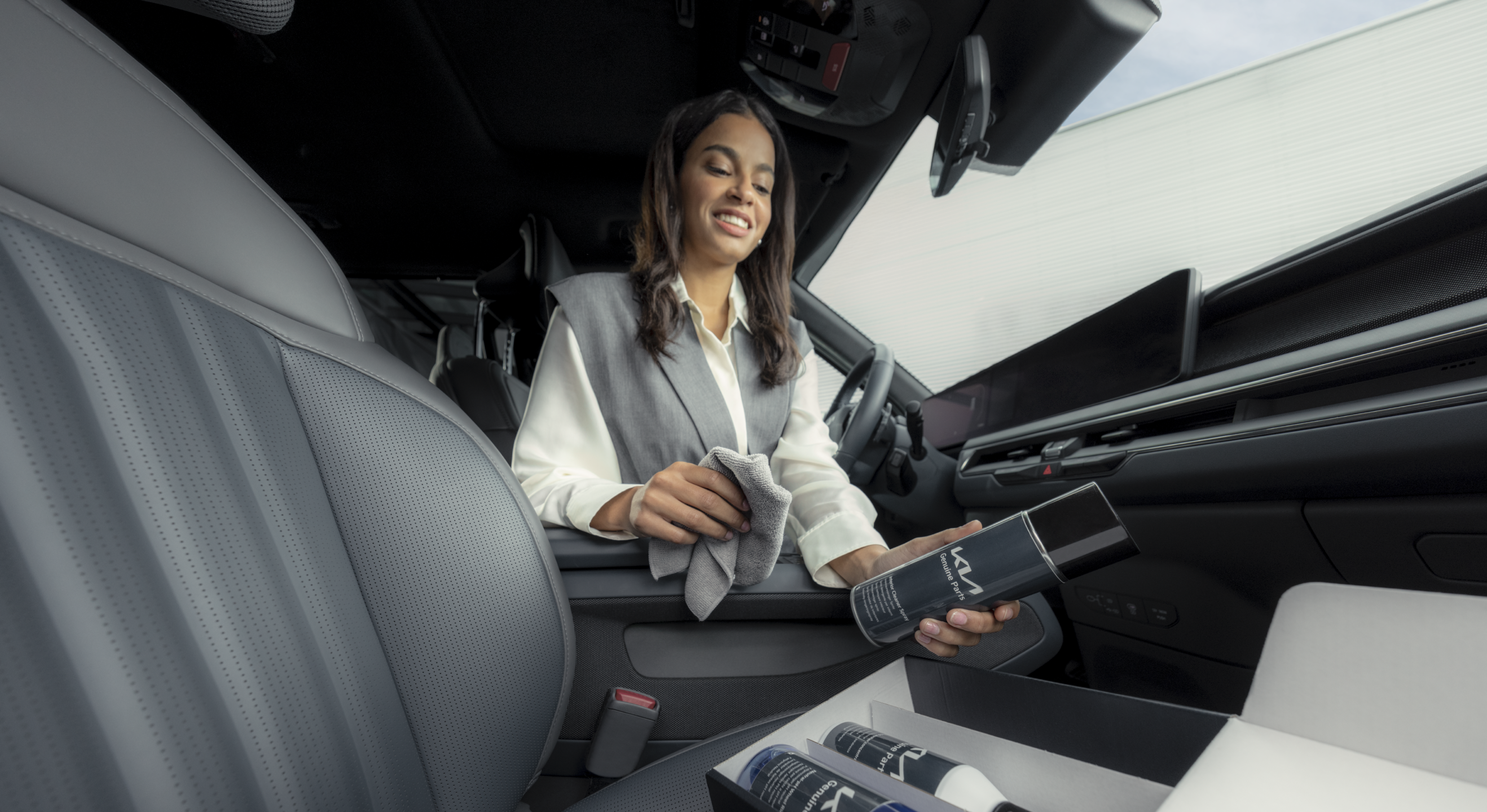 Kia owner cleans the cabin of her vehicle with the help of the Kia Genuine Parts Car Cleaning Set.