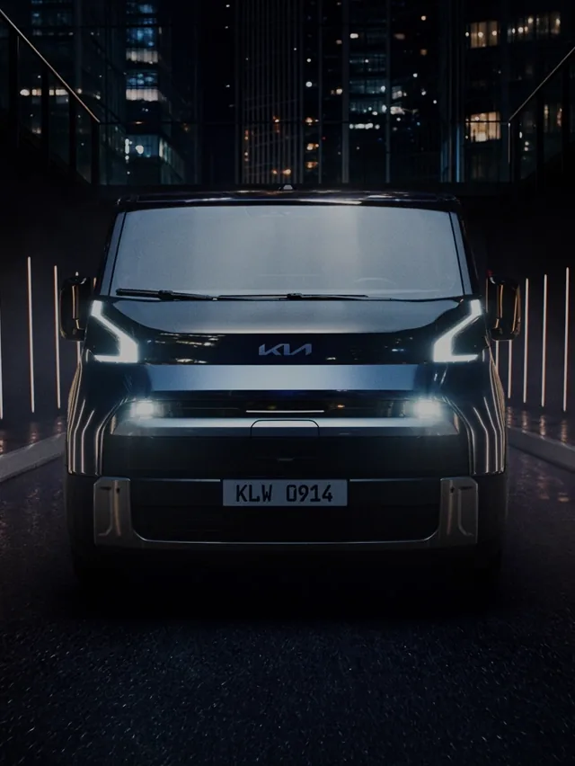 Front view of the Kia PV7 with its headlights illuminated at night.