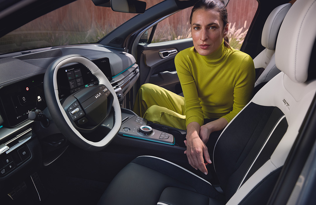 Vy av kupéns framsäten i Kia Sportage där en modell sitter i passagerarsätet. 