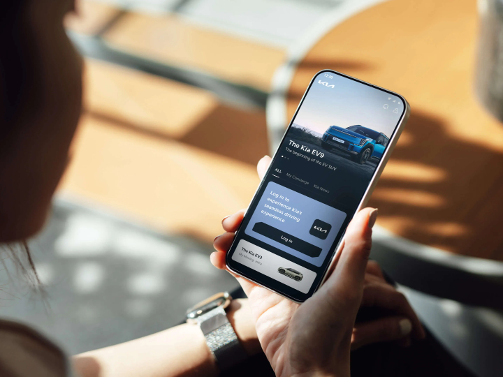 Person som håller i en mobil med Kia App.