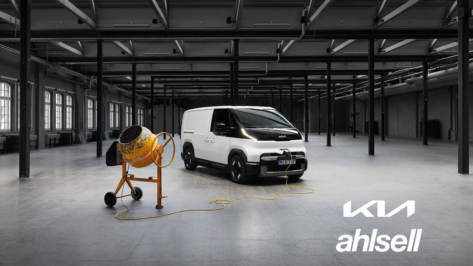 Kia PV5 Cargo med cementblandare intill.