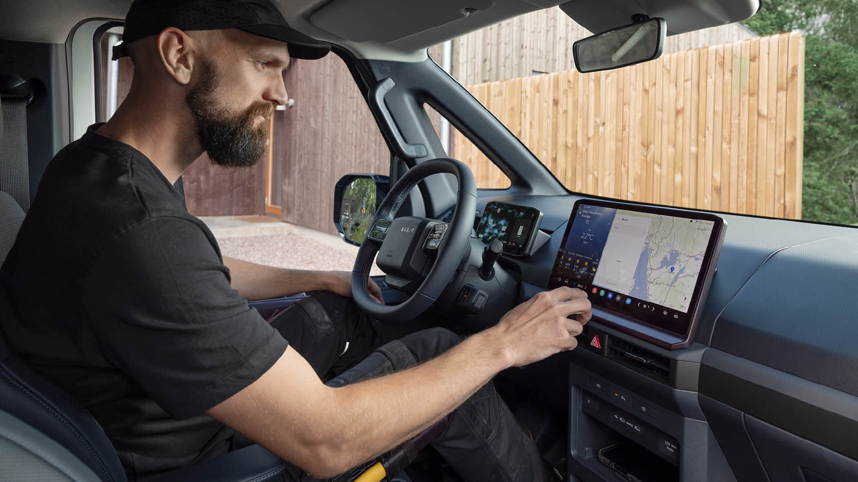 Instrumentbrädan i Kia PBV med infotainmentskärm som visar en navigationskarta och smarta kontroller.