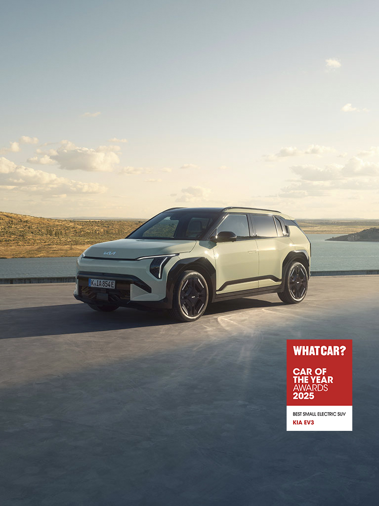 A Kia EV3 on a concrete platform near a lake