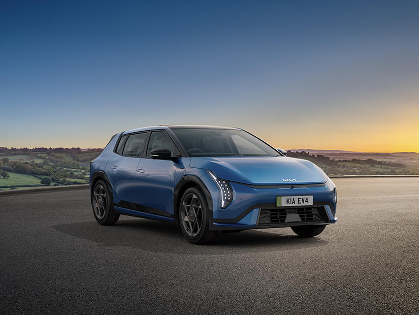 Kia EV4 in Blue Flame parked on an open road with a scenic countryside backdrop at sunset
