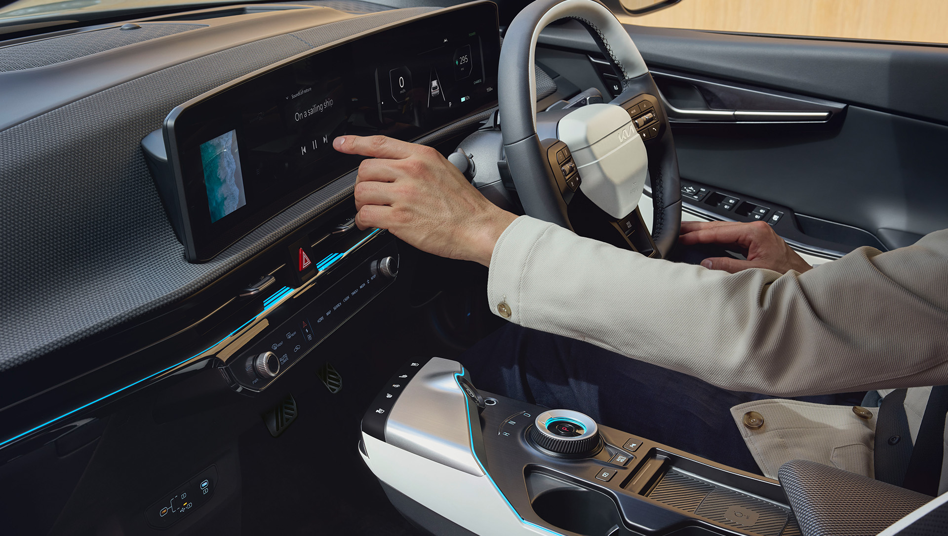 Inside a Kia EV6, a man operates the touchscreen