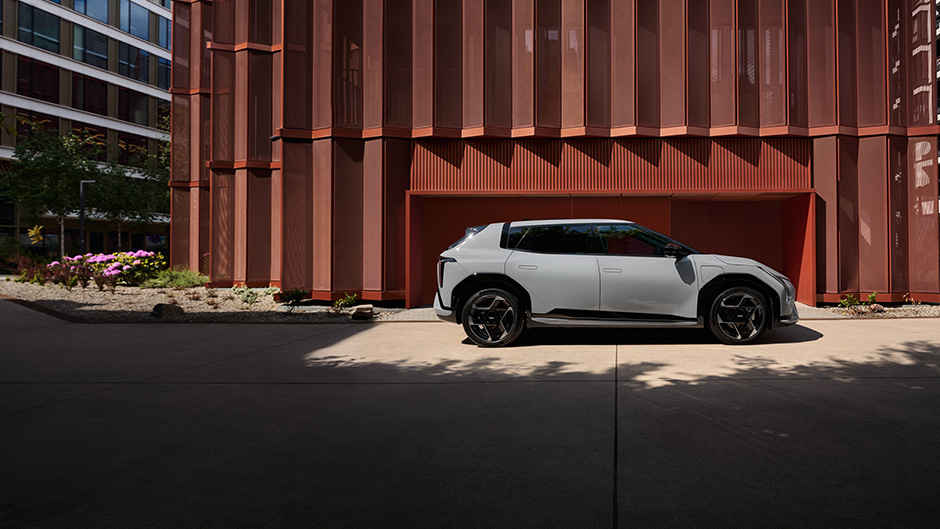 The Kia EV4 parked infront of a brown building