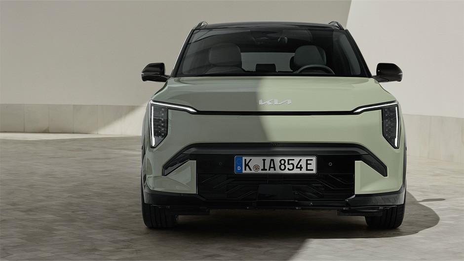 A front-facing profile of the GT-Line S EV3, in the colour Pistachio Green, parked in a modern building, with white walls around the EV.