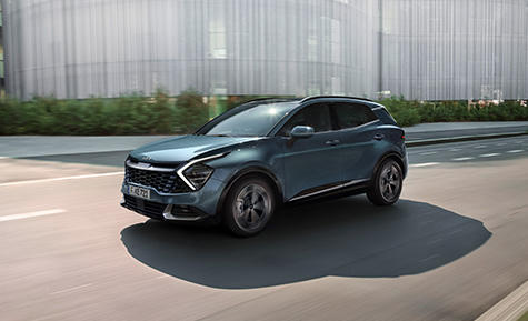 Sportage driving along a sunny city road